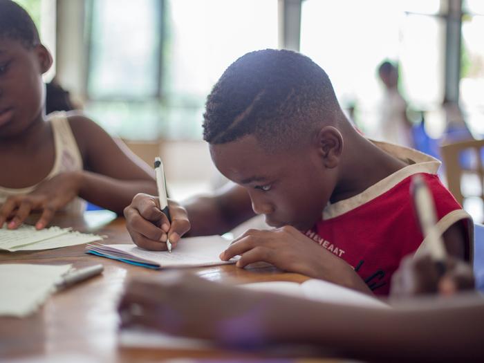 Boy writing in his notebook