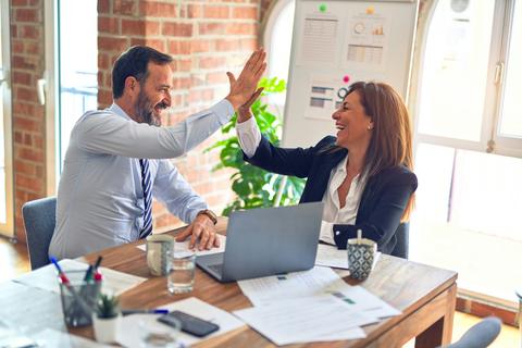 Coworkers celebrating with a high five