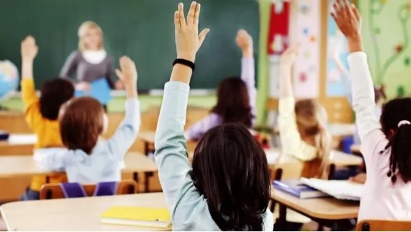 Students raising their hands in an English class
