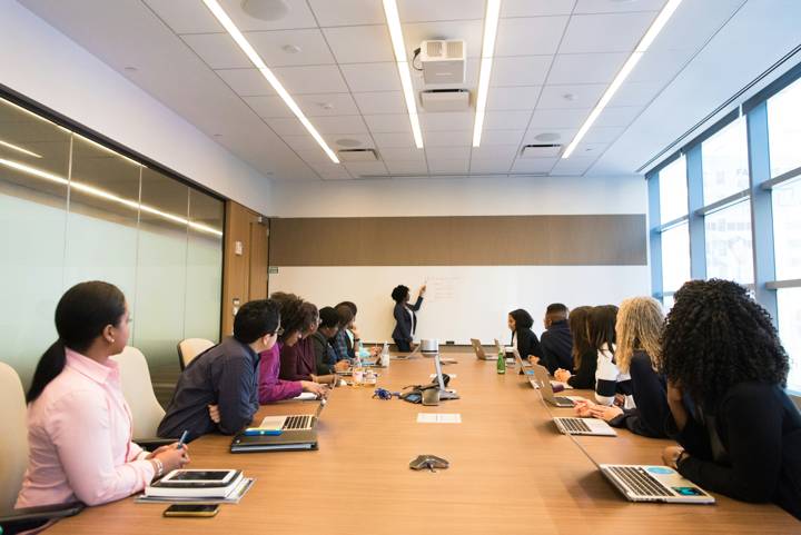 Adult students in a class with an instructor at the whiteboard